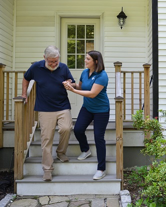 provider of senior care in Happy Valley assisting elderly patient down stairs