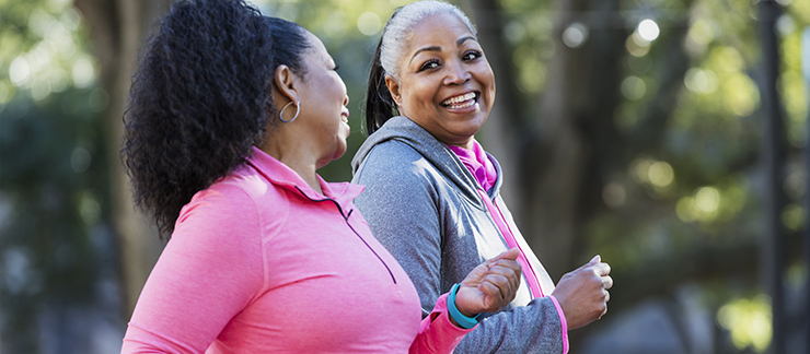 Two senior women taking a walk outdoors for exercise.