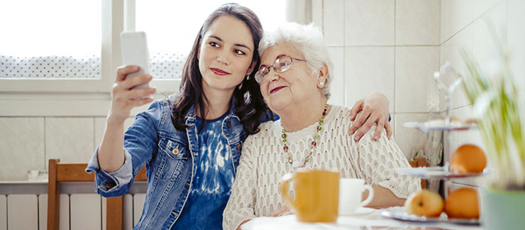 Millennial-aged female taking a selfie with her grandmother who she provides care.